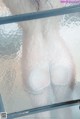 A close up of a woman's breasts in a shower.