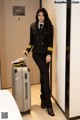 A woman in a pilot's uniform with a suitcase.