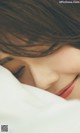 a close up of a person laying in bed with their eyes closed