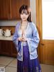 A woman in a blue and purple kimono posing for the camera.