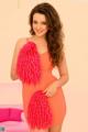 A woman in an orange dress holding a pink feather boa.