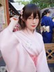 A woman in a pink kimono is posing for a picture.