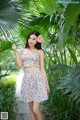 A woman in a floral dress posing for a picture.