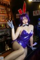 A woman in a bunny costume sitting at a bar.