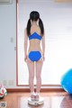 A woman in a blue bikini standing on a scale.