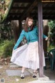 A woman in a blue sweater and a white tulle skirt.