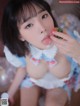 A woman in a blue and white dress eating a strawberry.