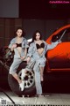 A couple of women sitting on top of a car.