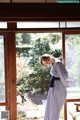 A woman standing in front of a sliding glass door.