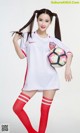 A woman in a soccer uniform holding a soccer ball.